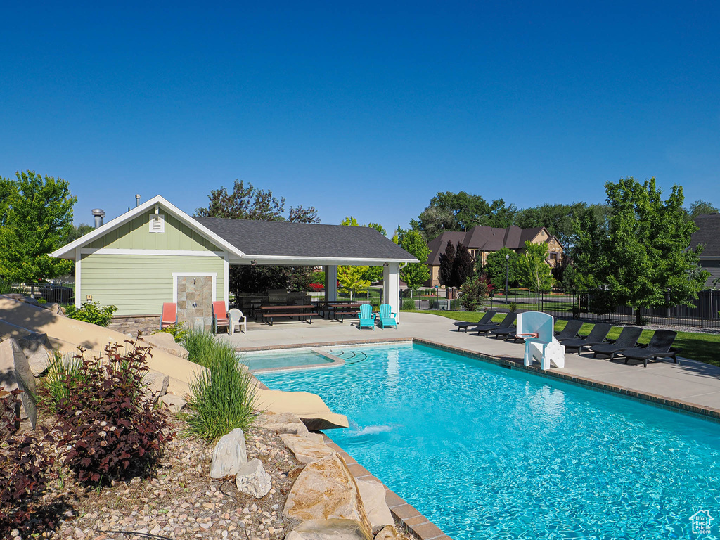 View of pool with a patio area, a pool with connected hot tub, and a gazebo