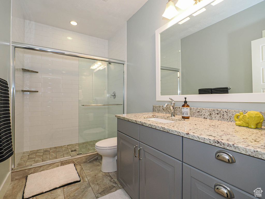 Full bath featuring toilet, a shower stall, vanity, and recessed lighting