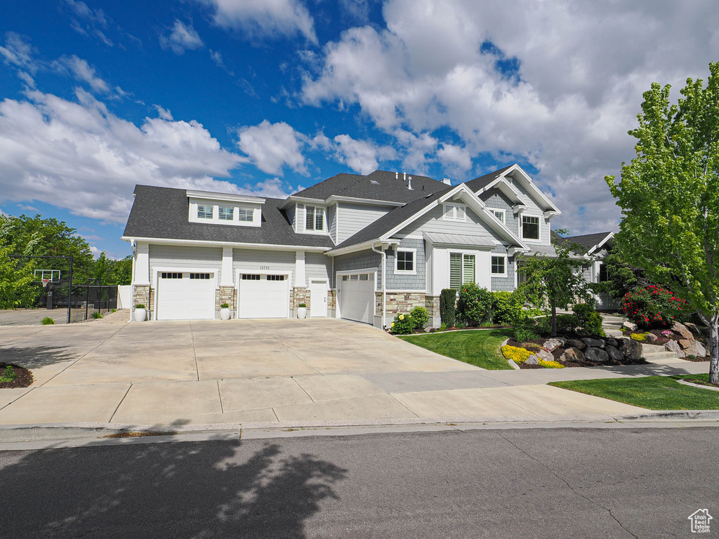 Craftsman inspired home with stone siding and driveway