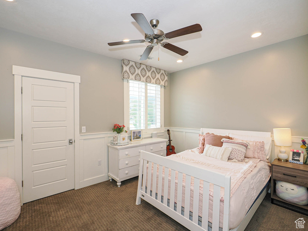 Carpeted bedroom with a wainscoted wall, recessed lighting, and ceiling fan