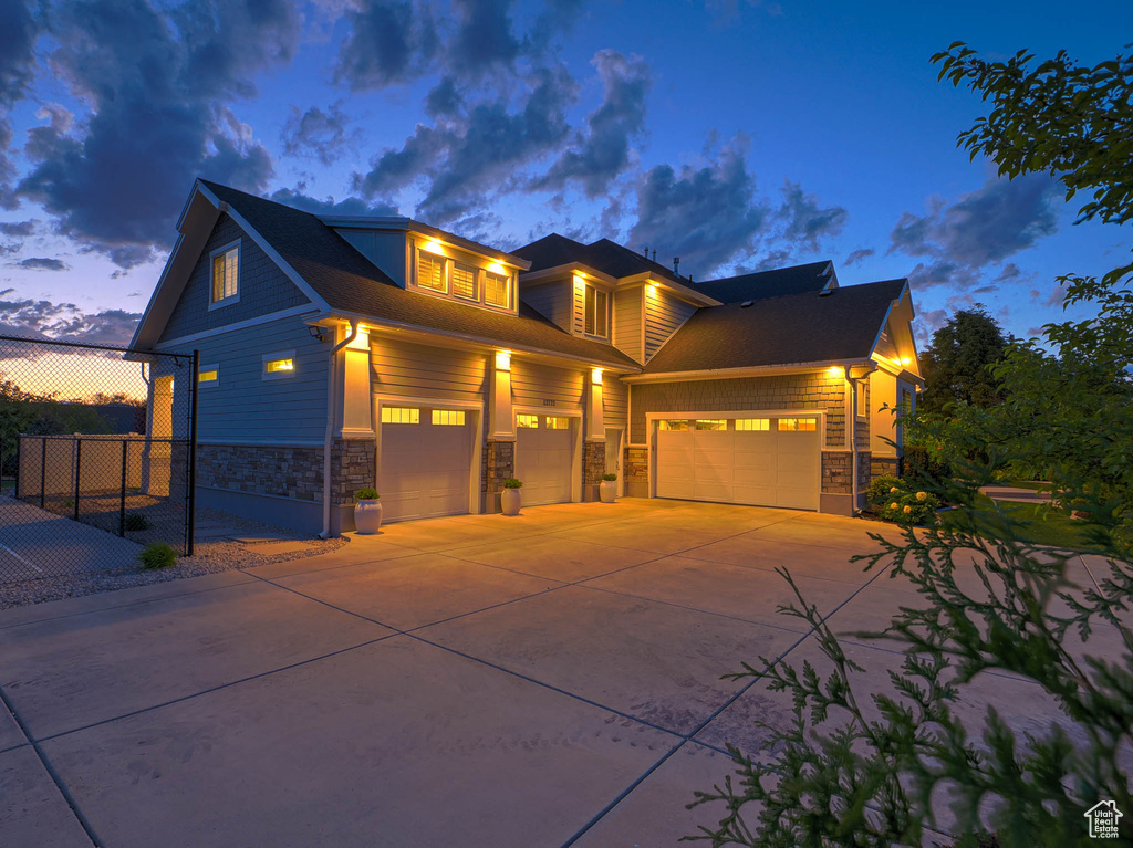 View of front of house featuring stone siding and driveway