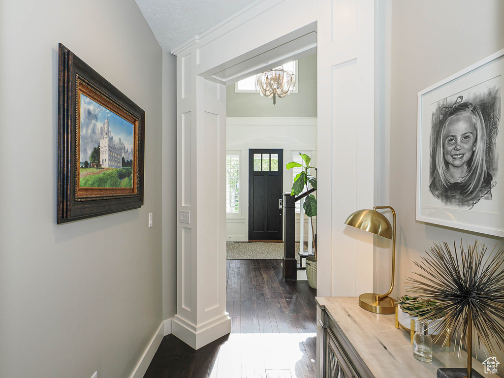 Foyer entrance featuring a chandelier, dark wood finished floors, and baseboards