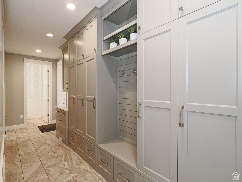 Mudroom featuring recessed lighting, light marble finish floors, and baseboards