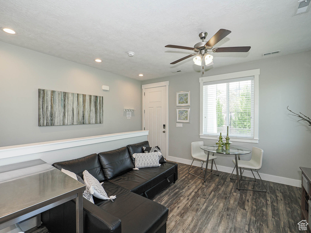 Living area with a ceiling fan, wood finished floors, baseboards, and recessed lighting