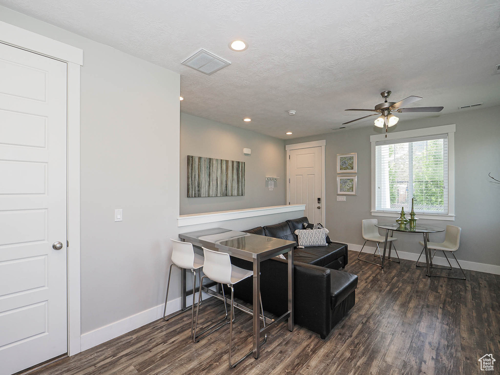 Living room with dark wood-style floors, baseboards, ceiling fan, recessed lighting, and a textured ceiling