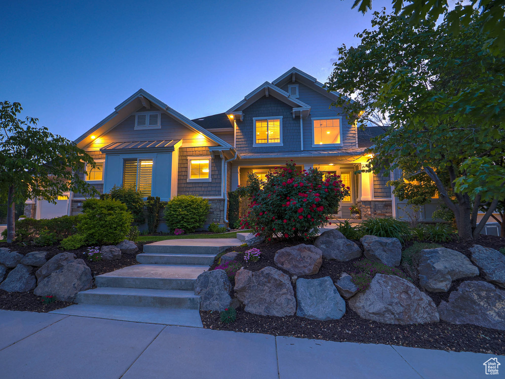 Craftsman-style house with stone siding and a standing seam roof