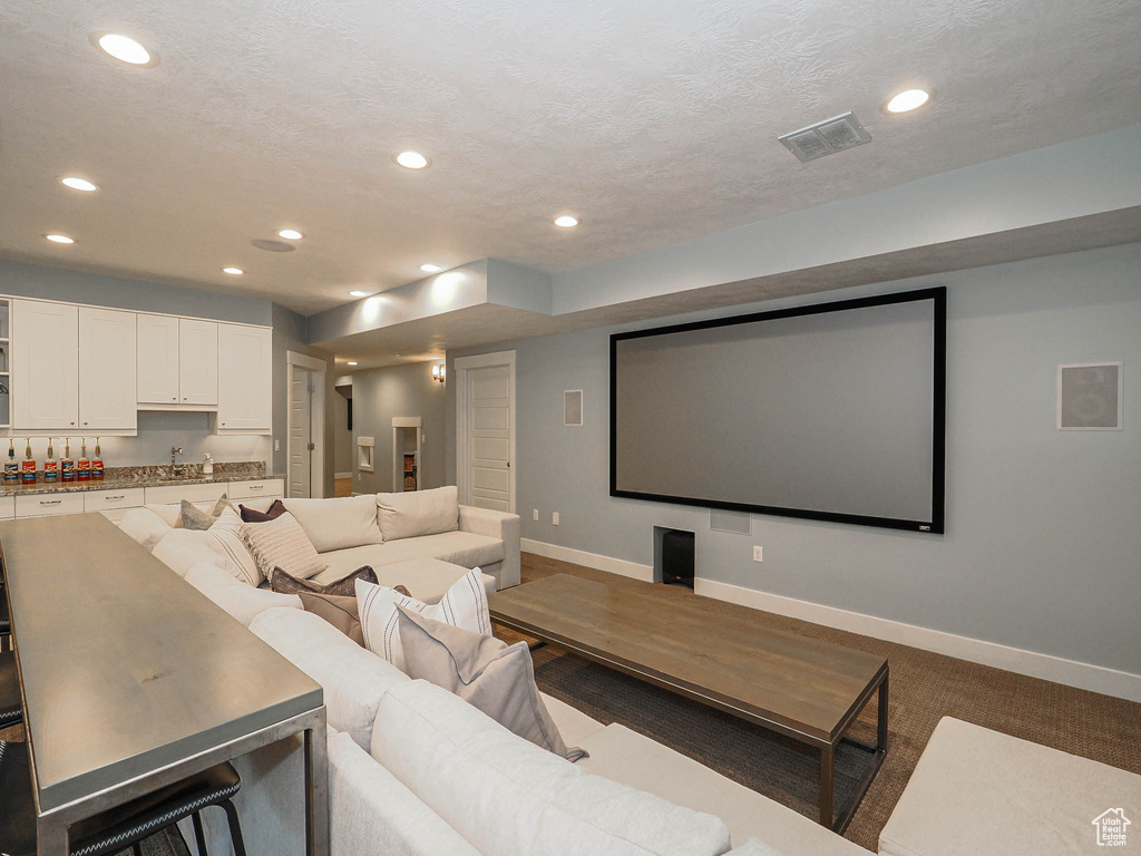 Cinema room featuring baseboards, recessed lighting, and a sink