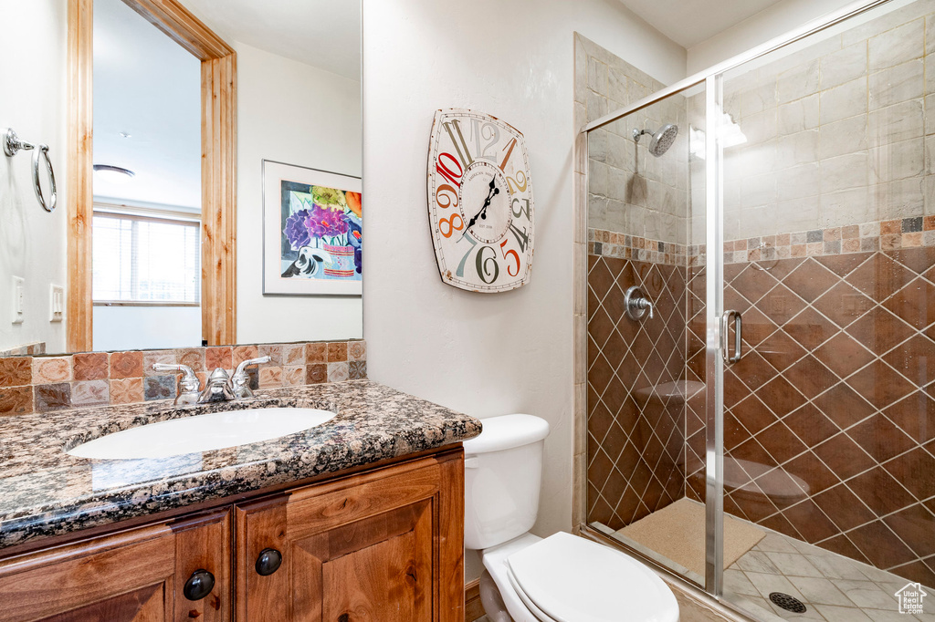 Bathroom with vanity, toilet, and a shower stall
