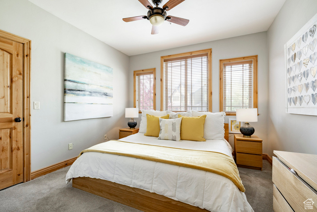 Bedroom with carpet floors, baseboards, and a ceiling fan
