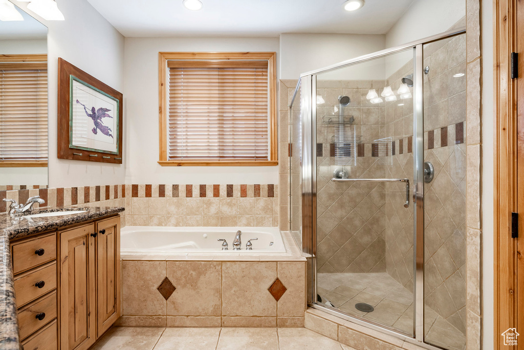 Bathroom featuring vanity, a garden tub, a stall shower, tile patterned flooring, and recessed lighting