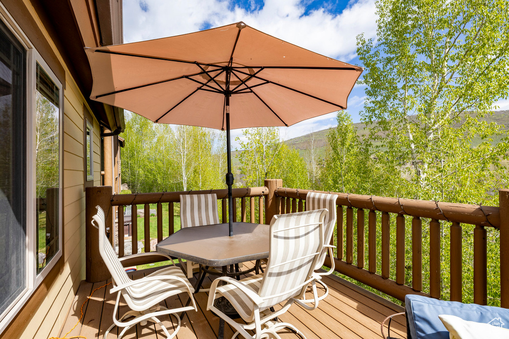 Wooden deck with outdoor dining area and a baseboard heating unit