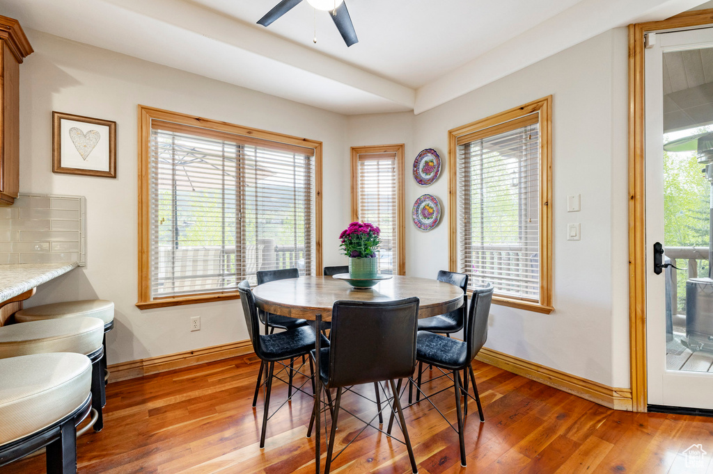 Dining space featuring light wood-type flooring, a ceiling fan, healthy amount of natural light, and baseboards