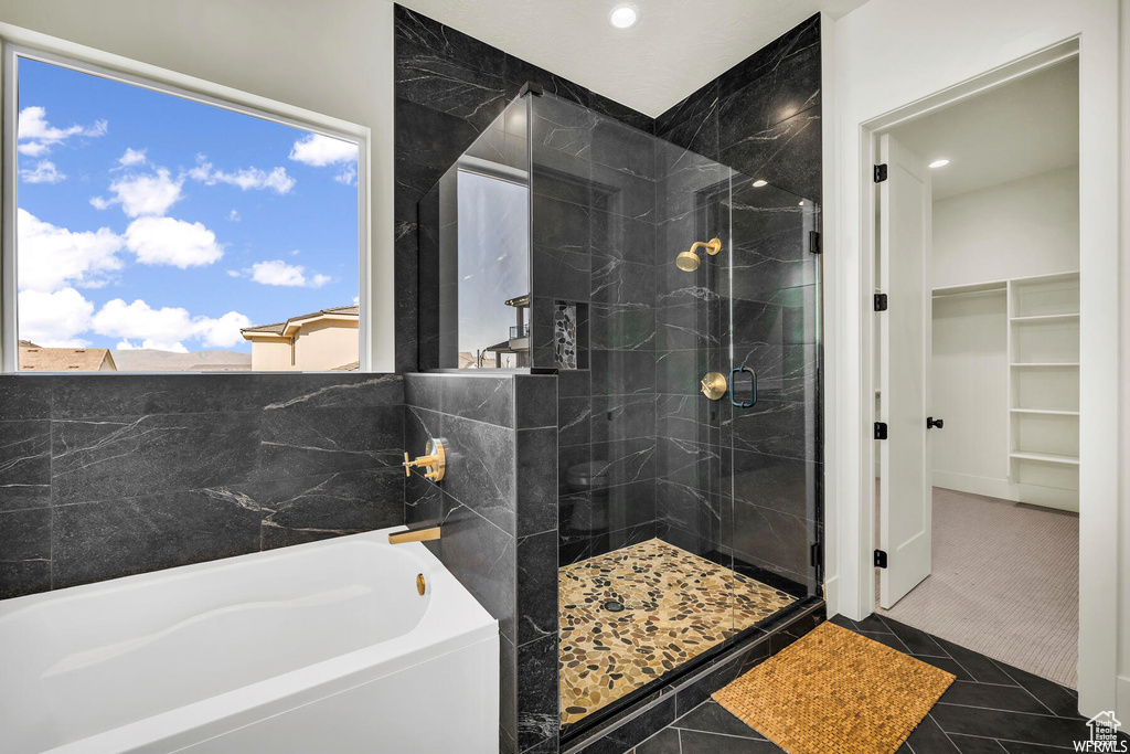 Bathroom featuring a garden tub, a stall shower, a walk in closet, recessed lighting, and tile patterned floors