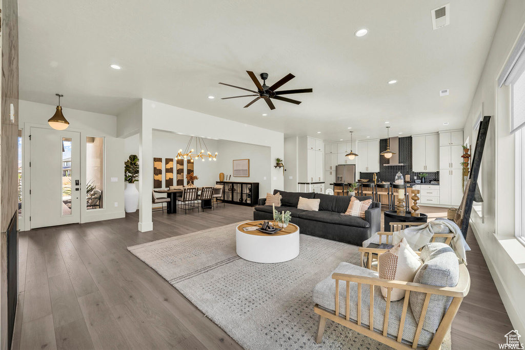 Living area with a chandelier, wood finished floors, recessed lighting, and ceiling fan