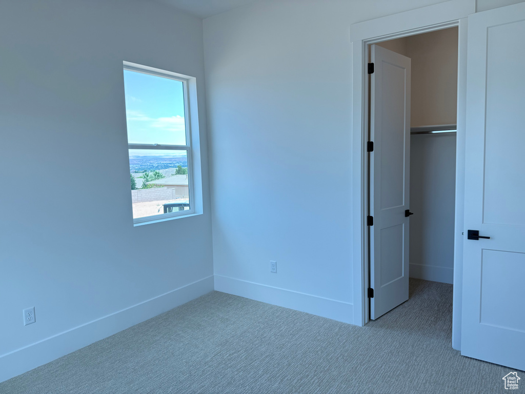 Unfurnished bedroom featuring carpet and a closet