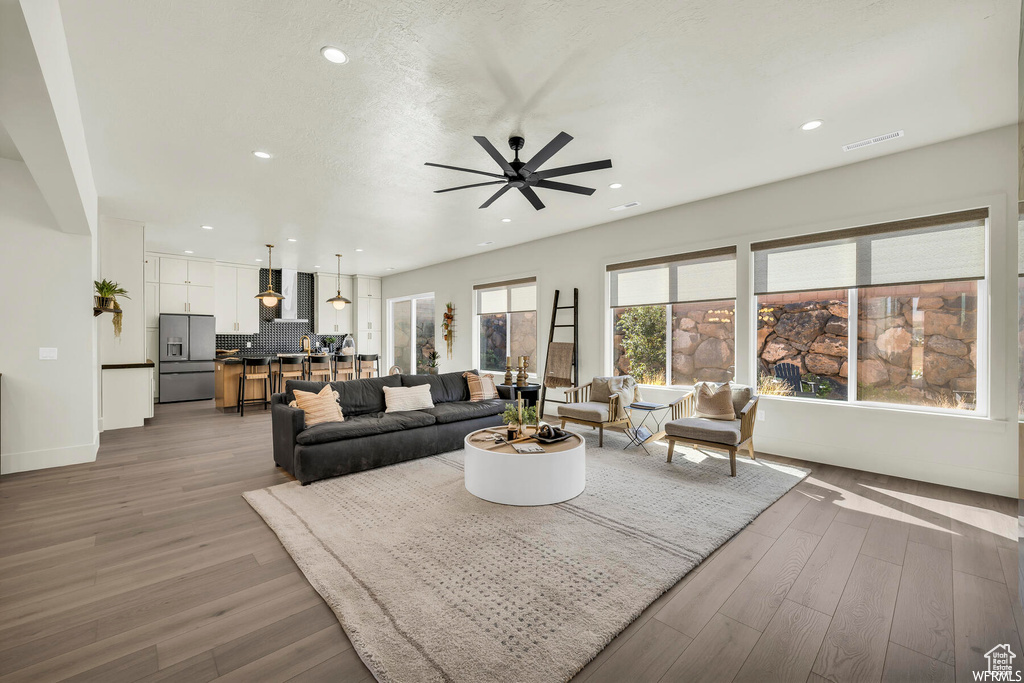 Living area with ceiling fan, recessed lighting, wood finished floors, and baseboards