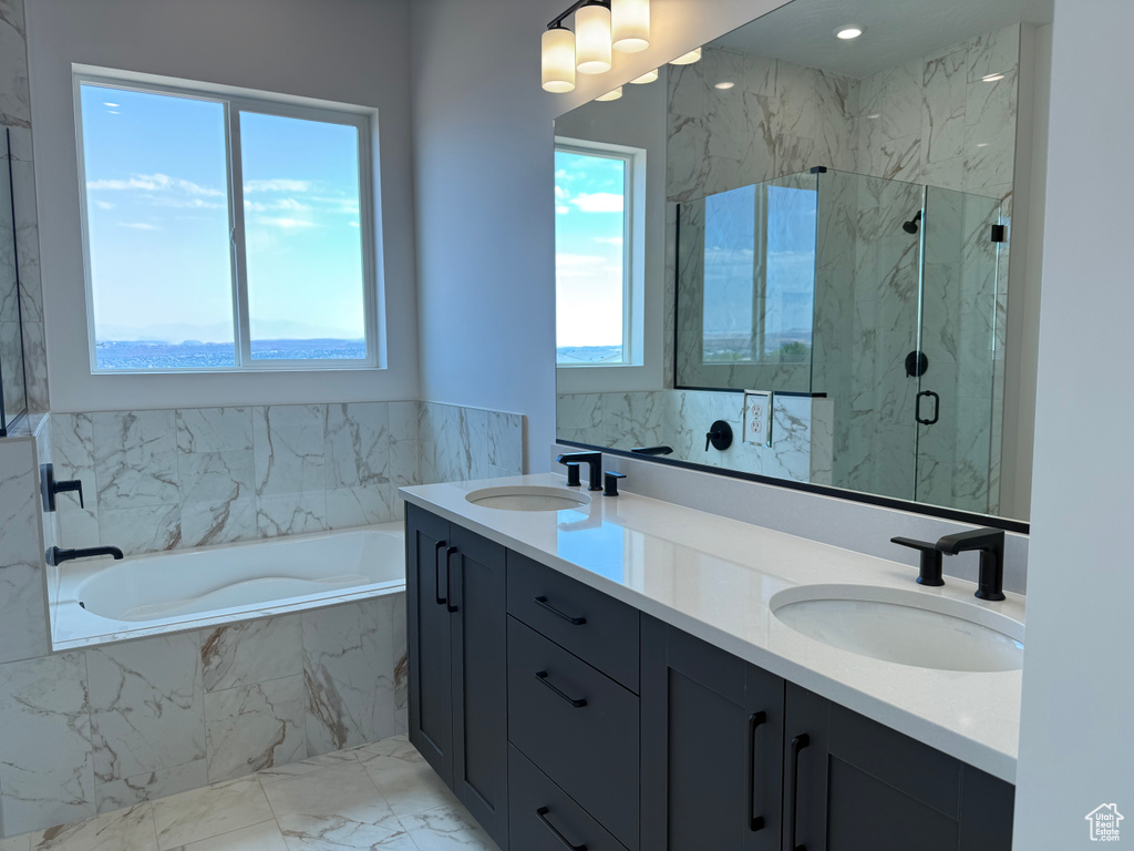 Bathroom featuring a garden tub, a marble finish shower, double vanity, and marble finish flooring