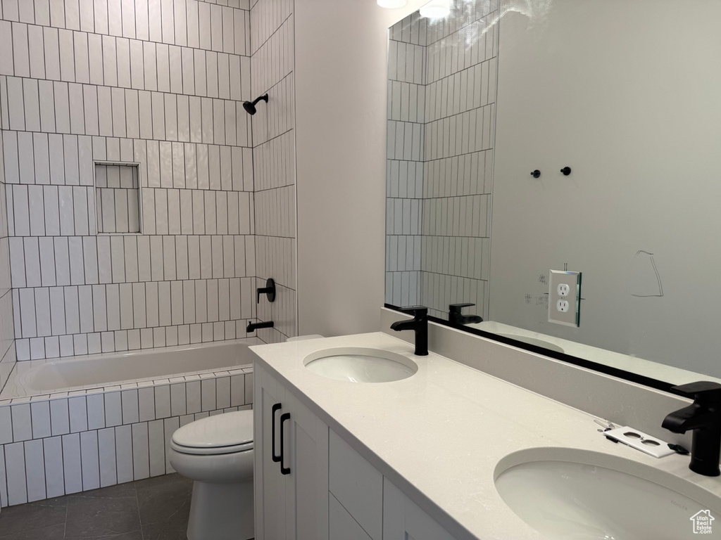 Full bath with tile patterned flooring, double vanity, and tiled shower / bath