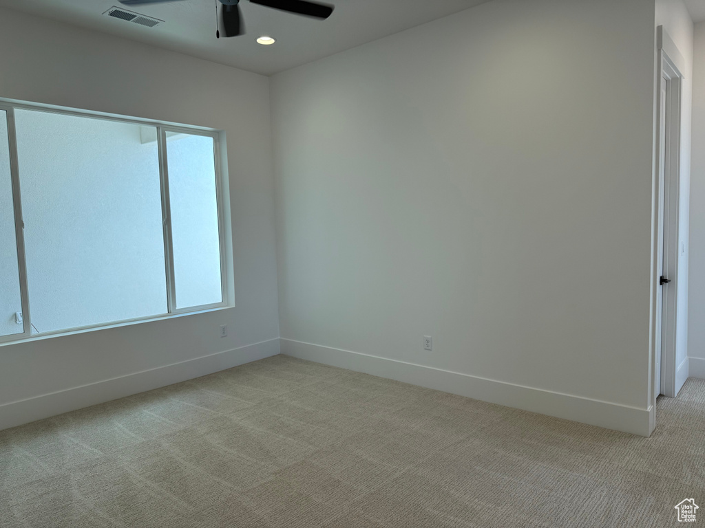 Empty room with light colored carpet, a ceiling fan, healthy amount of natural light, and recessed lighting