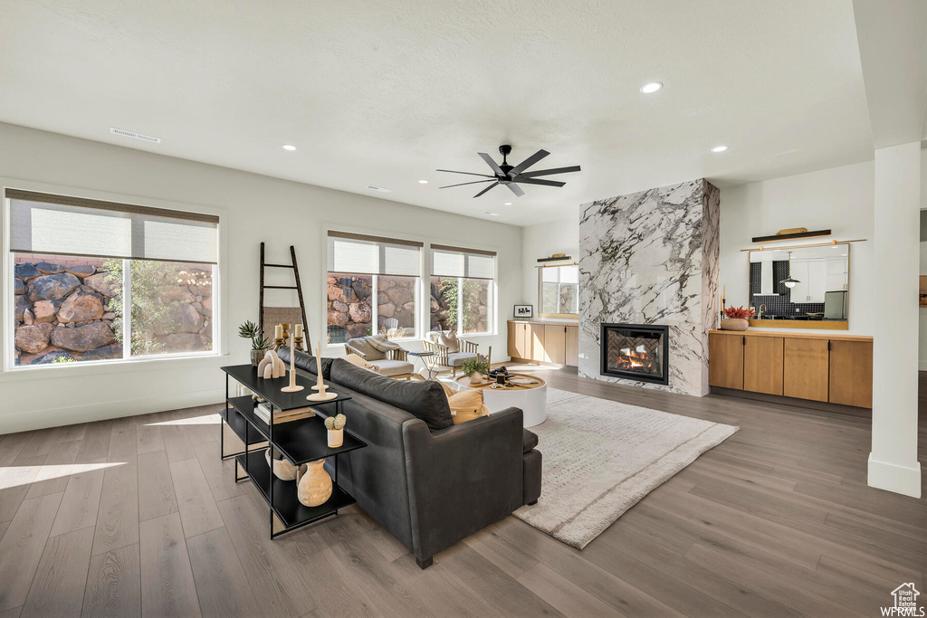 Living area with ceiling fan, wood finished floors, a fireplace, recessed lighting, and baseboards