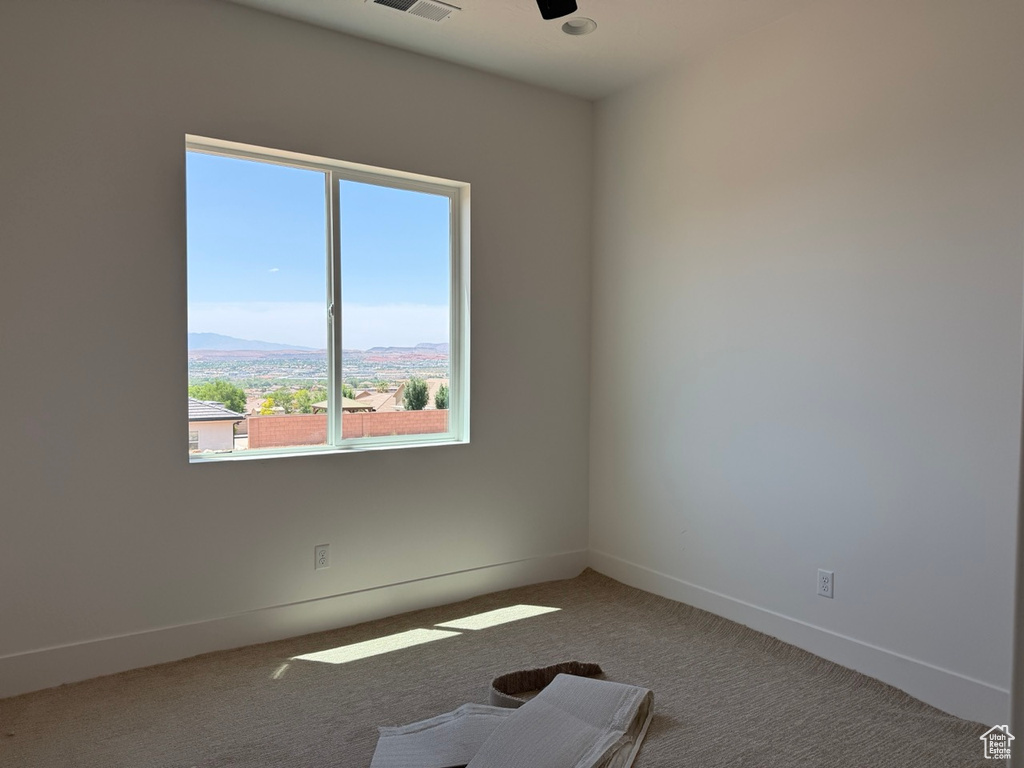 Unfurnished room featuring carpet flooring and a ceiling fan
