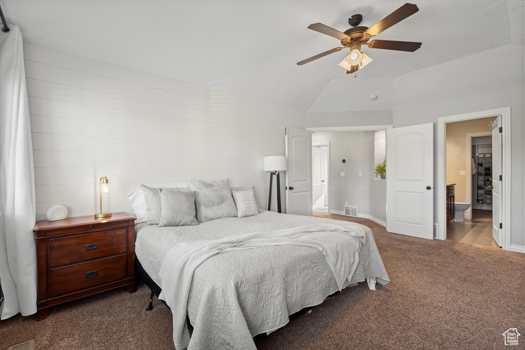 Carpeted bedroom with connected bathroom, a ceiling fan, and vaulted ceiling