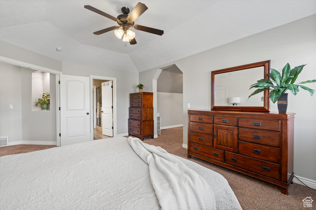 Bedroom featuring light colored carpet, arched walkways, baseboards, and lofted ceiling