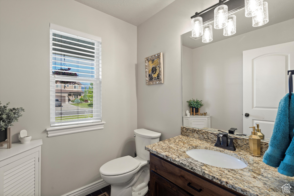 Half bath featuring vanity, toilet, and baseboards