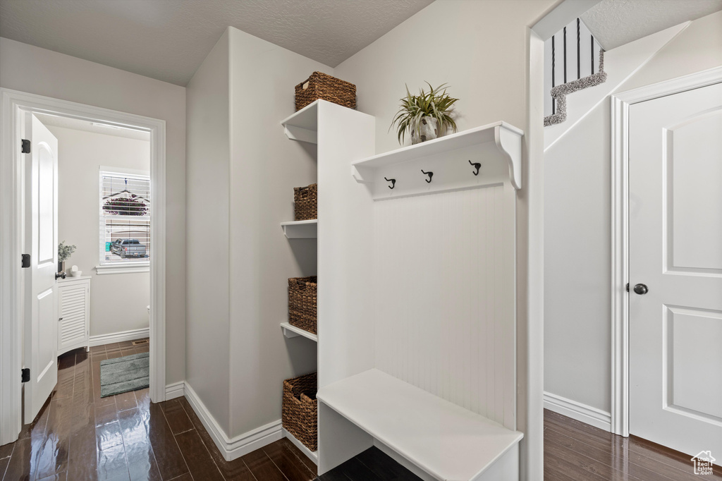 Mudroom with dark wood-style flooring and baseboards