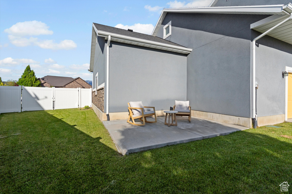Back of property with a patio, stucco siding, and a gate