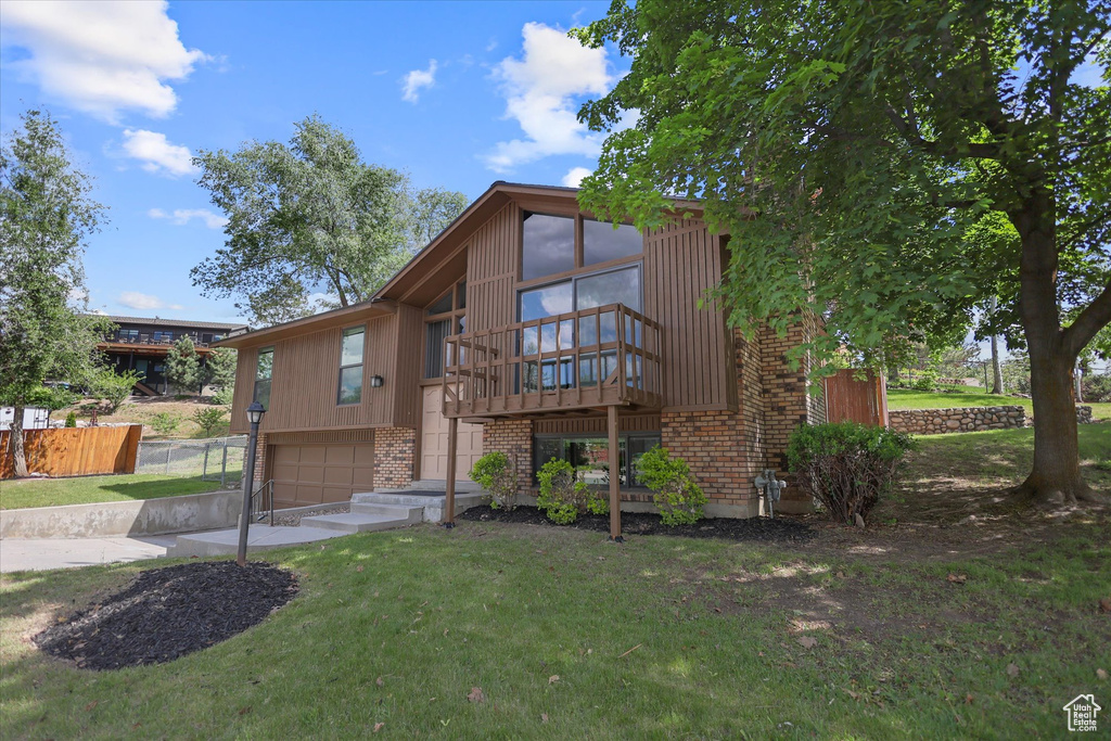 View of front of home with a garage, brick siding, and concrete driveway