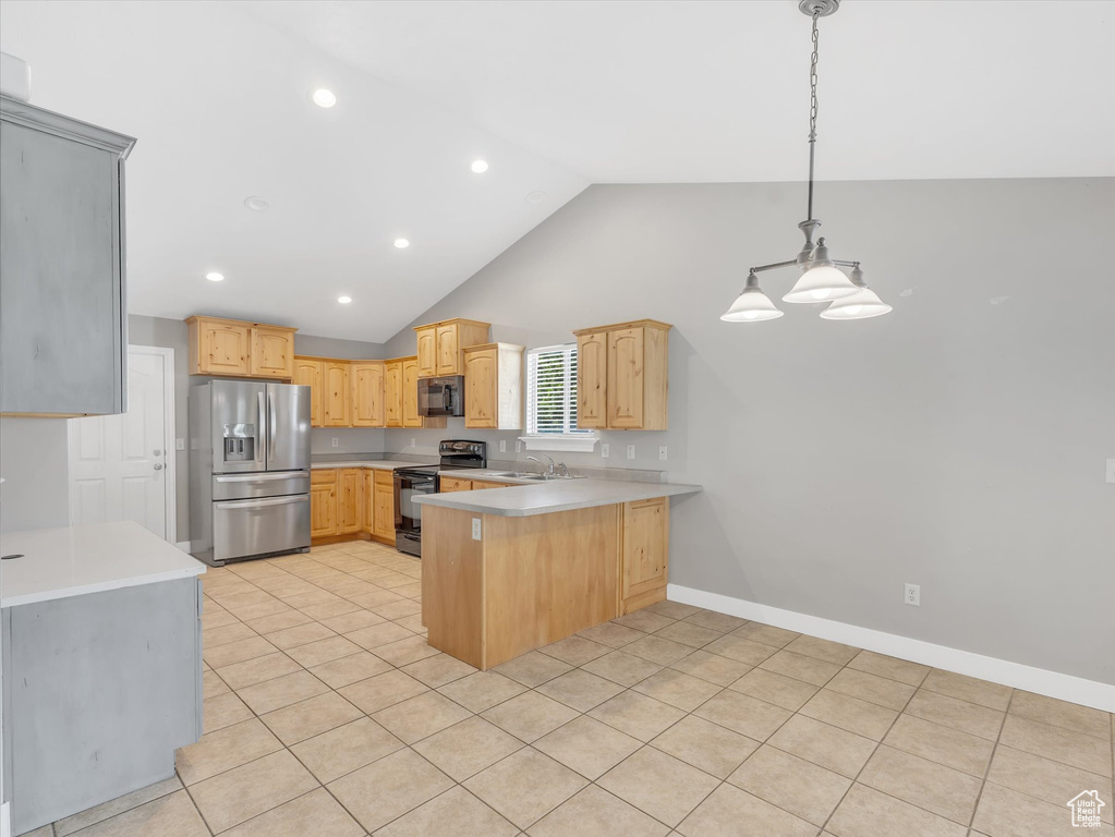 Kitchen featuring black appliances, a peninsula, light countertops, a sink, and light tile patterned floors
