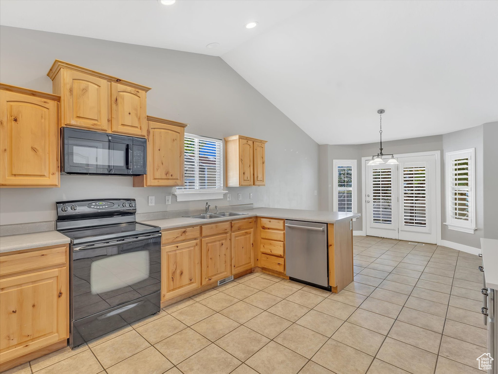 Kitchen featuring black appliances, light brown cabinets, a sink, lofted ceiling, and recessed lighting