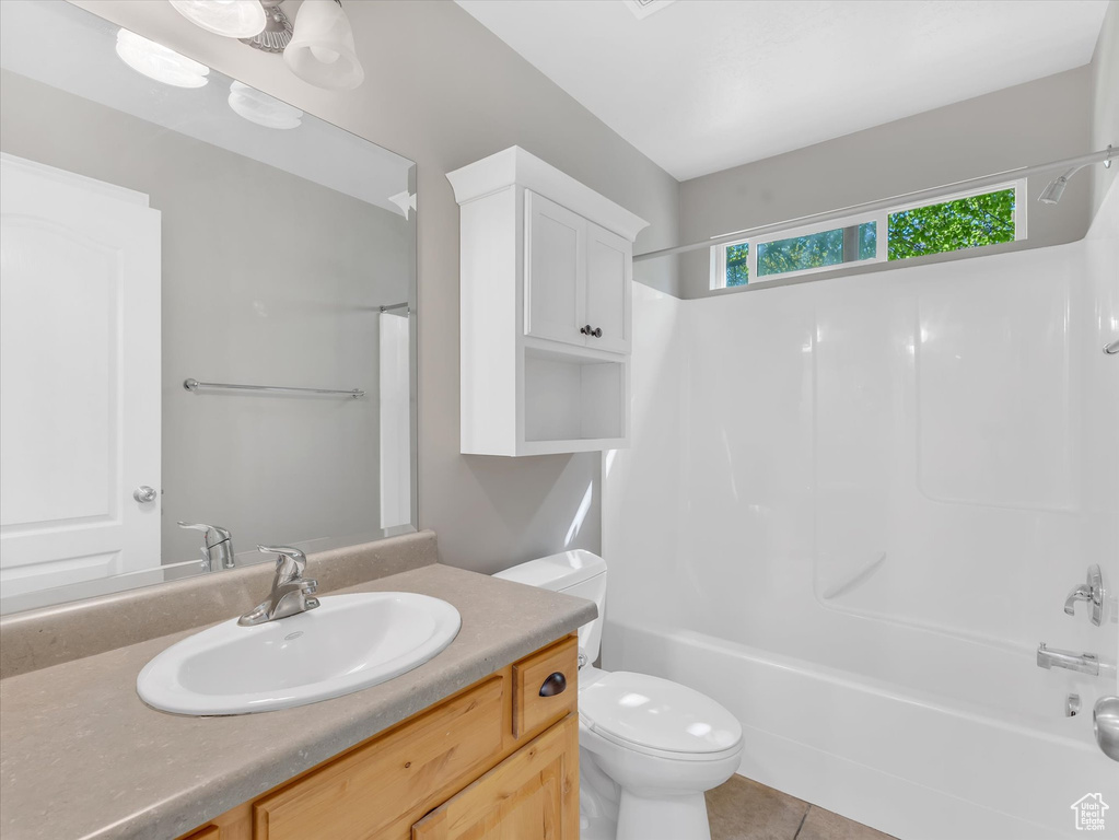 Full bathroom featuring toilet, vanity, washtub / shower combination, and tile patterned flooring