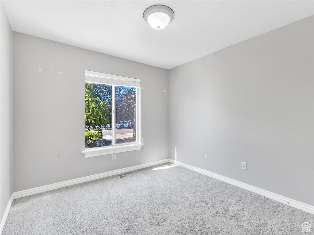 Carpeted empty room with baseboards