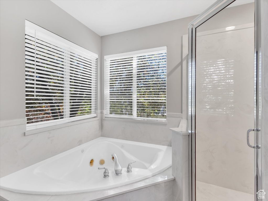 Full bath with a stall shower and a jetted tub