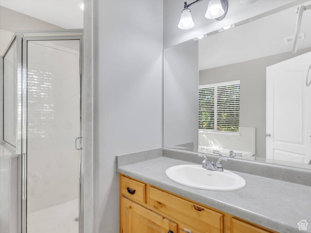 Full bathroom with vanity and a shower stall