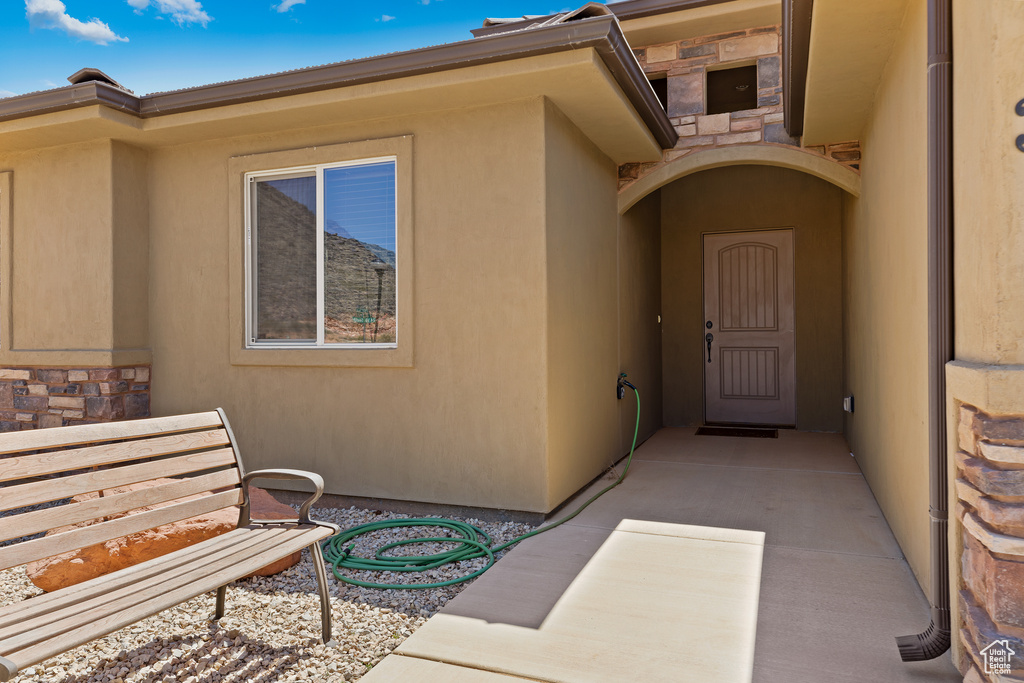 Entrance to property with stone siding and stucco siding