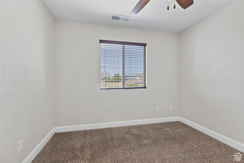 Spare room with carpet flooring, a ceiling fan, and baseboards