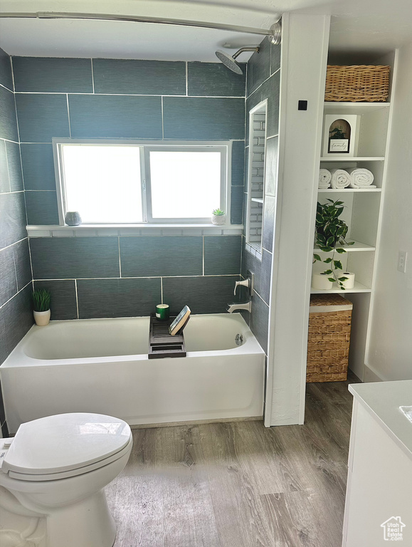 Full bath with wood finished floors, toilet, vanity, and shower / bath combination