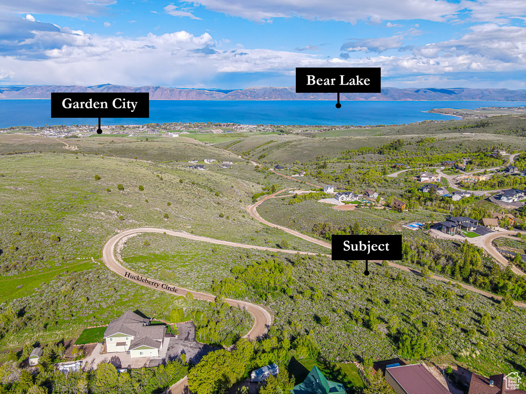 Aerial view of property and surrounding area with a water and mountain view