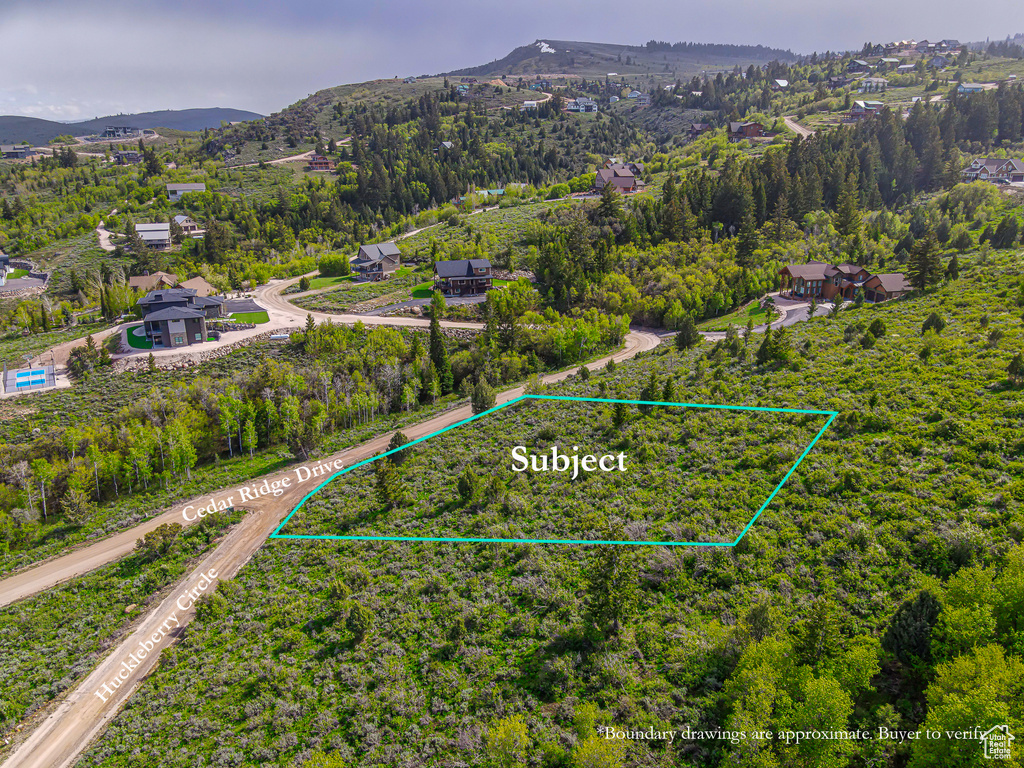 View of property location featuring property parcel outlined, a mountain backdrop, and a heavily wooded area