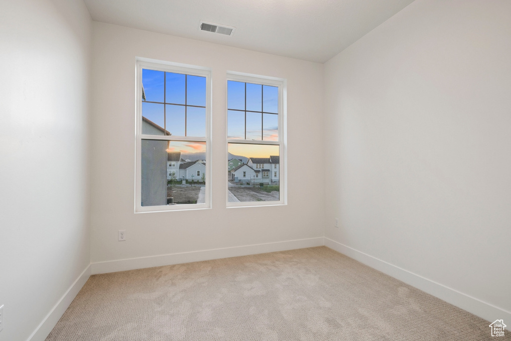 Carpeted spare room with baseboards