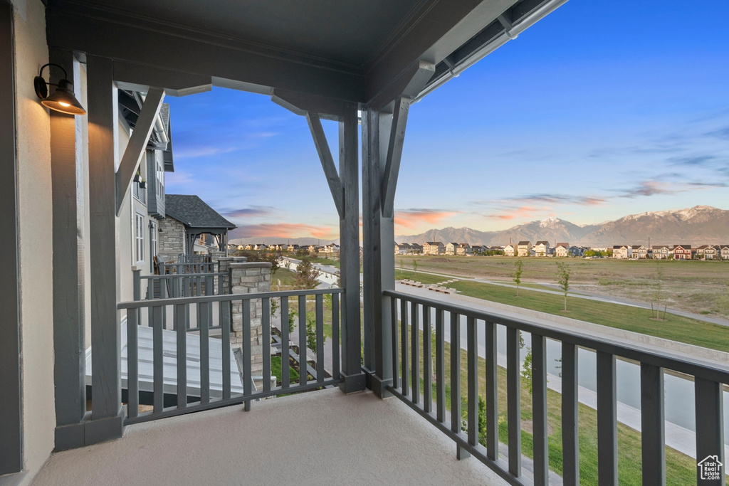 Balcony at dusk featuring a mountain view