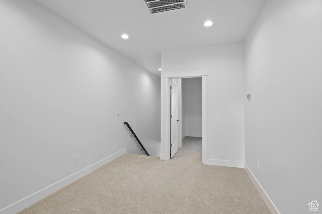 Spare room featuring recessed lighting, light colored carpet, and baseboards