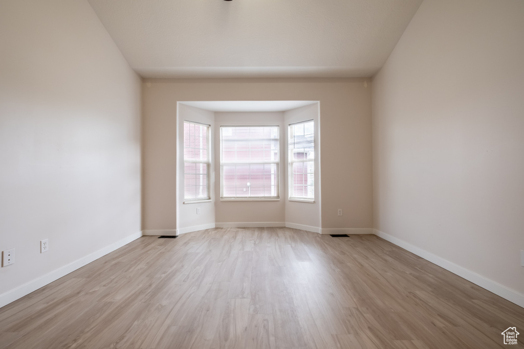 Unfurnished room with wood finished floors and baseboards