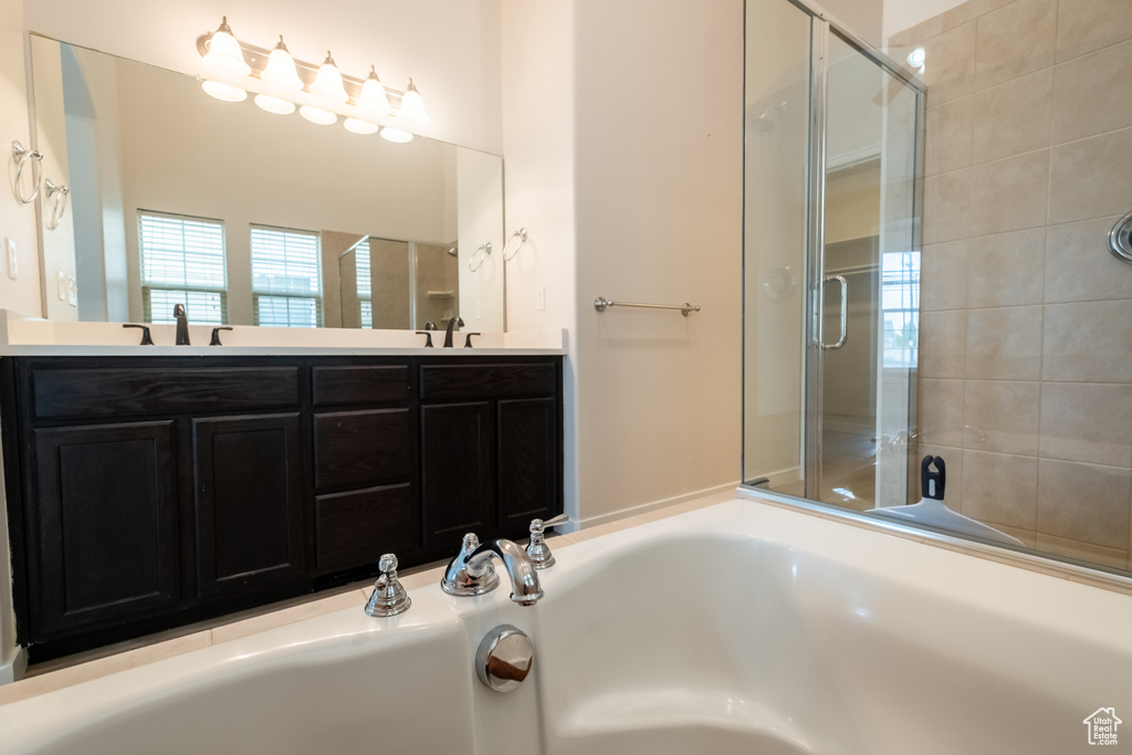 Bathroom with a bath, a stall shower, and double vanity