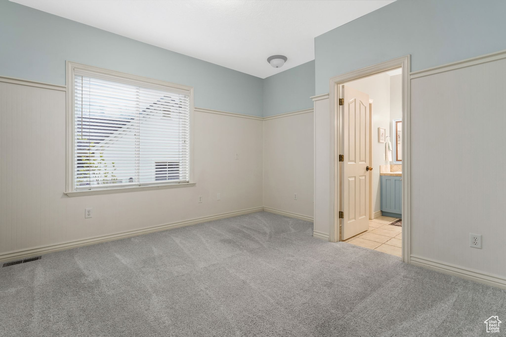 Unfurnished bedroom featuring carpet, baseboards, and ensuite bathroom