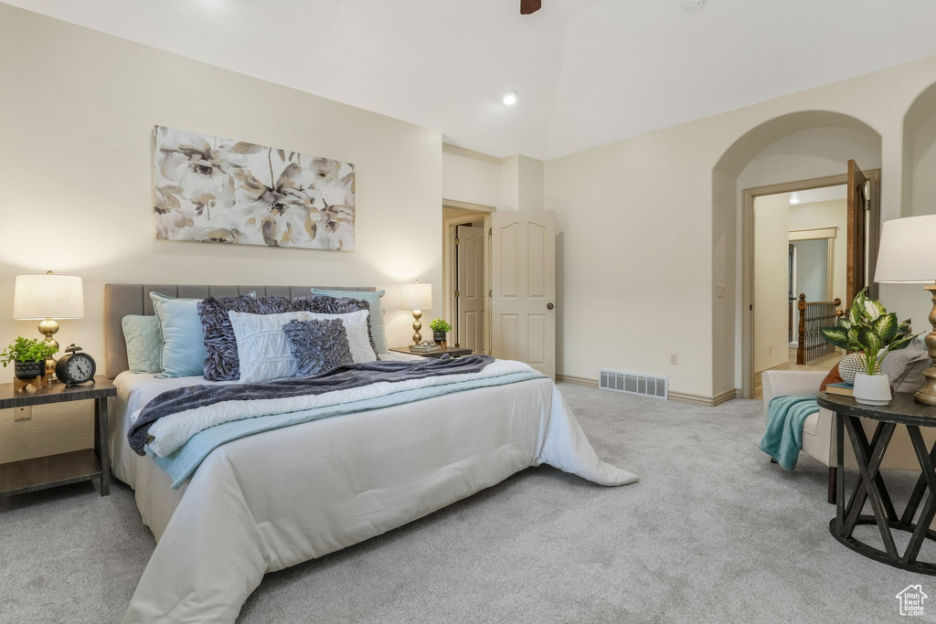 Carpeted bedroom featuring arched walkways and baseboards