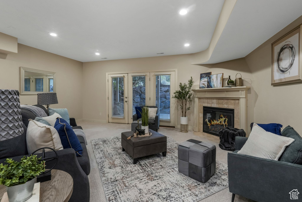 Carpeted living room featuring recessed lighting, a tiled fireplace, and baseboards